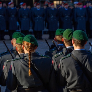 Sonnenlicht fällt beim feierlichen Gelöbnis der Bundeswehr auf dem Marktplatz in Haldensleben auf Soldaten und Soldatinnen der Ehrenformation. Im Hintergrund sind Rekruten und Rekrutinnen der Bundeswehr zu sehen.