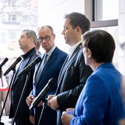 Markus Söder, Friedrich Merz, Lars Klingbeil und Saskia Esken stehen bei einer Pressekonferenz vor den Mikrofonen. Friedrich Merz schaut seitlich in die Kamera. 